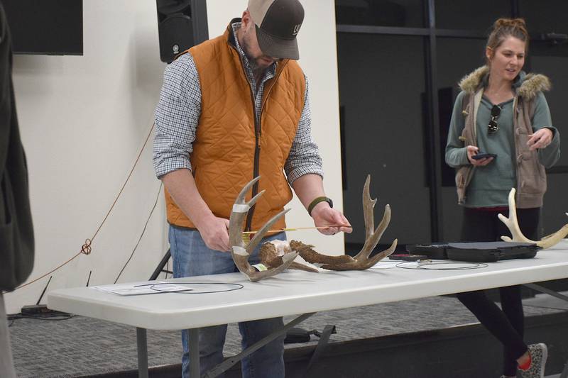 Taaffe Caligiuri demonstrates how to measure the inside spread of a white-tailed deer antler.