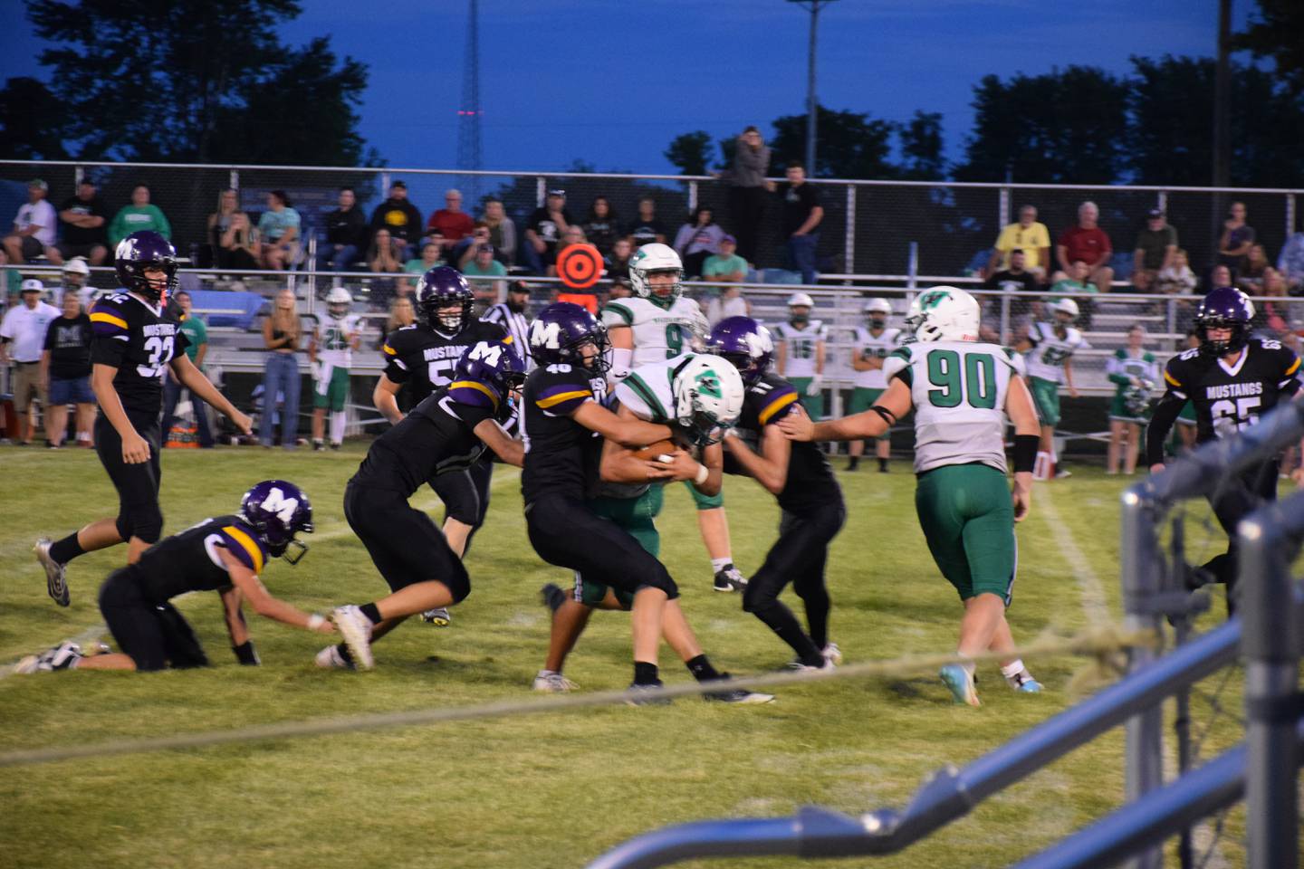 A group of Mustangs form left - Jaxon Darby, Wyatt Patton (4) and AJ Clarke (11) work to take down opponent Jamison Ewing. Mustangs also pictured are Brayden LeMastres (32), Keegan Chew (kneeling), Trevor Eckels (behind Darby) and Ace Neisemier (65).