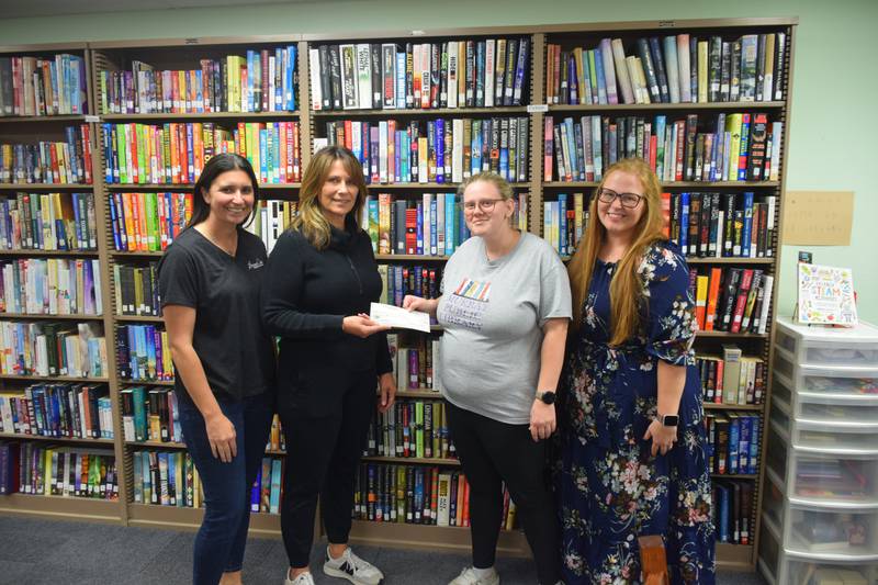 Stoney Oak broker/owner Paula McClaflin presents a check to Murray Public Library director Taylor Wilson that matched funds raised earlier in October. Kristin Flaherty, left, with Stoney Oak and Murray Development Corporation and Anna Tiffany, right, with the Murray Library Board were helpers in organizing the fundraiser.