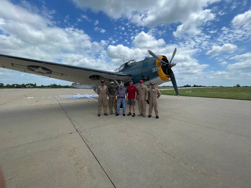 Lyle Persels, third from left, and Kevin Seuferer, third from right, are flanked by the pilot-in-command, left, and crew of the Avenger.