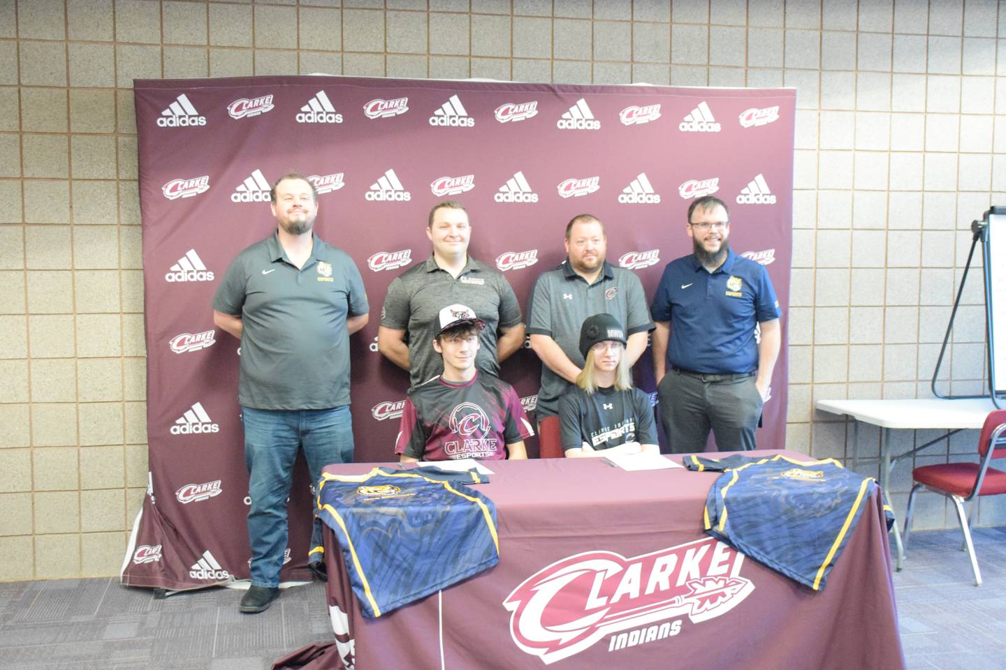 Hunter Reilli-Kight and Justin Hollinger pose with Marshalltown Community College esports coaches Dr. Andrew Goforth, left, and Nathan Rodemeyer right. Middle left is Clarke head esports coach Shane Wagoner, and middle right is esports coach Chris Claybaker.