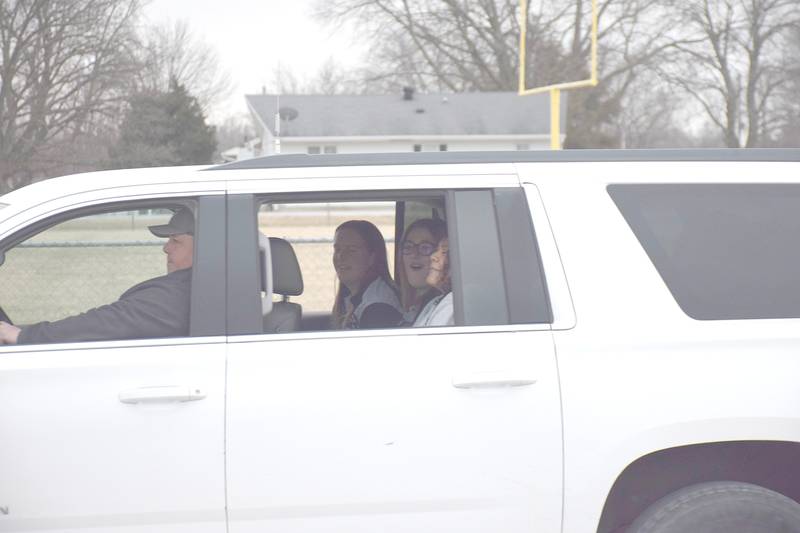 Mallory Tidman (center) is escorted out of town Feb. 4 to the state girls wrestling tournament.