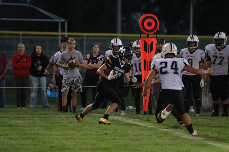 Murray’s Ayden Lamb, #18, runs past Hunter DeGard, #24, of Melcher-Dallas last Friday at Murray’s first game of the season.