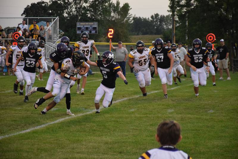 AJ Clarke (11) works to take down Lenox’s Laramie Stoaks at last Friday’s home game. Jumping in on the tackle is Keaton Brammer (5), with Wylee Wright (23) running in to help. Other Mustangs pictured are Trevor Eckels (57) and Grady Mongar (52).