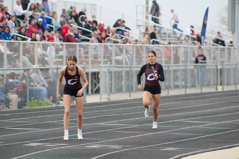 Piper Hertz waits for the hand-off from Victoria Rosales in the 4x200-meter relay race. Home meet, 4-17-2025